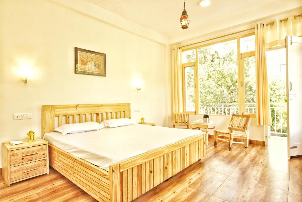 マナリにあるThe Culture Nation Hostel Manaliのベッドルーム1室(大型ベッド1台、テーブル、椅子付)