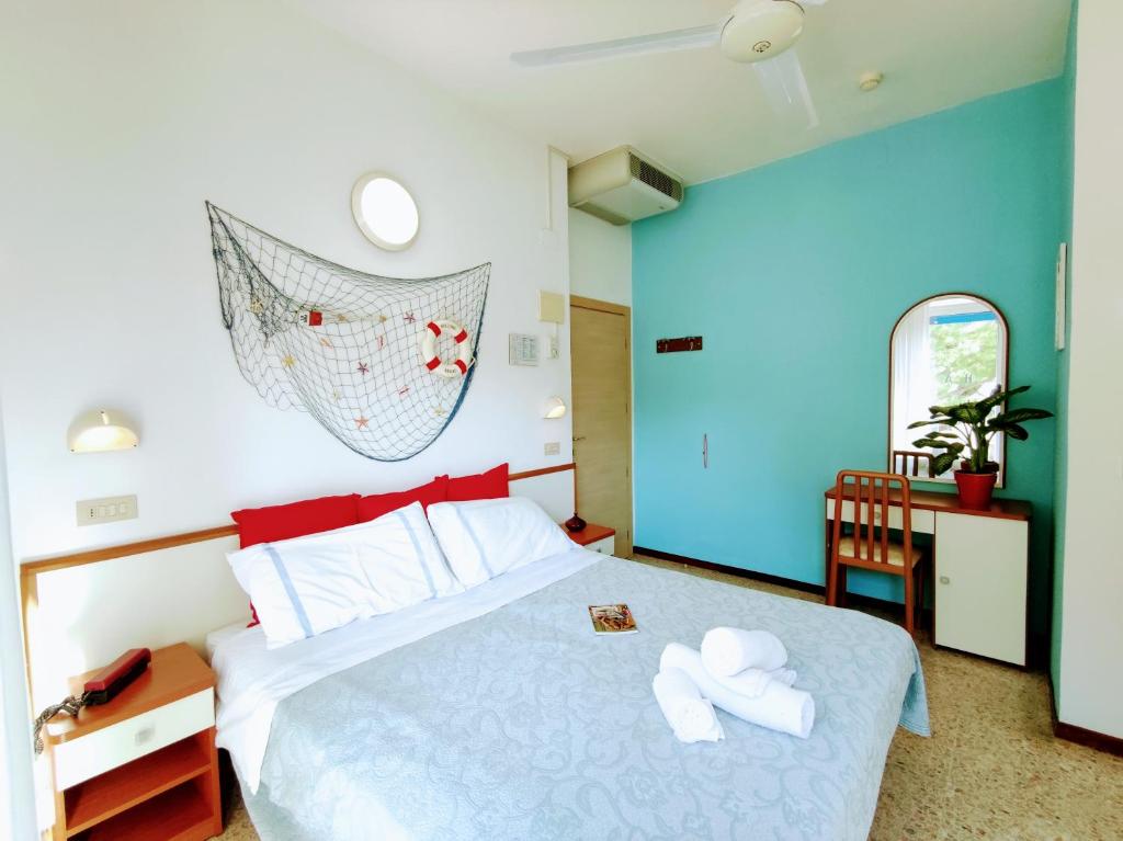 una camera da letto con un letto e due asciugamani di Hotel Adria B&B - Colazione fino alle 12 a Misano Adriatico