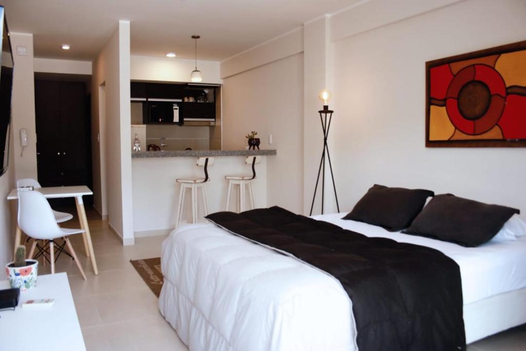 a bedroom with a large white bed and a kitchen at Dorrego l in Junín