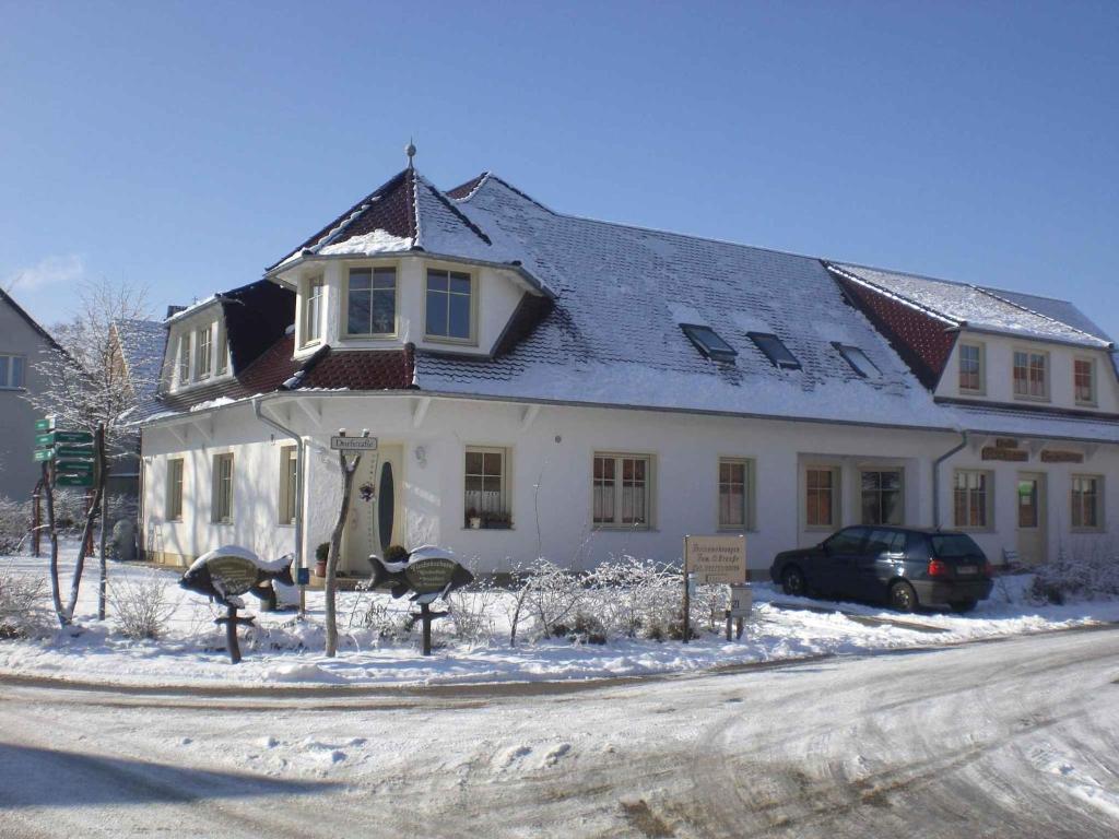 Una gran casa blanca con nieve en el suelo en Apartments in Trebbin 26568, en Trebbin