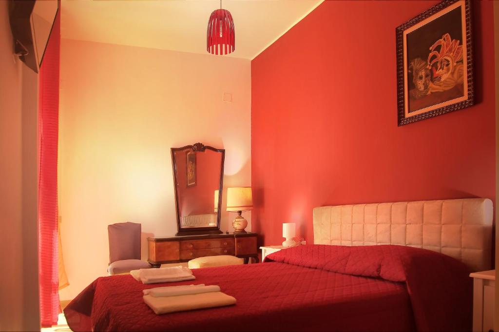 a red bedroom with a bed and a mirror at B&B Bibliotechina in Naples