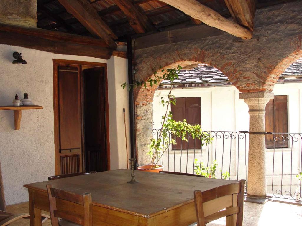 drewniany stół w pokoju z balkonem w obiekcie Apartment Madonna Del Sasso/Piemont 22865 w mieście Madonna del Sasso
