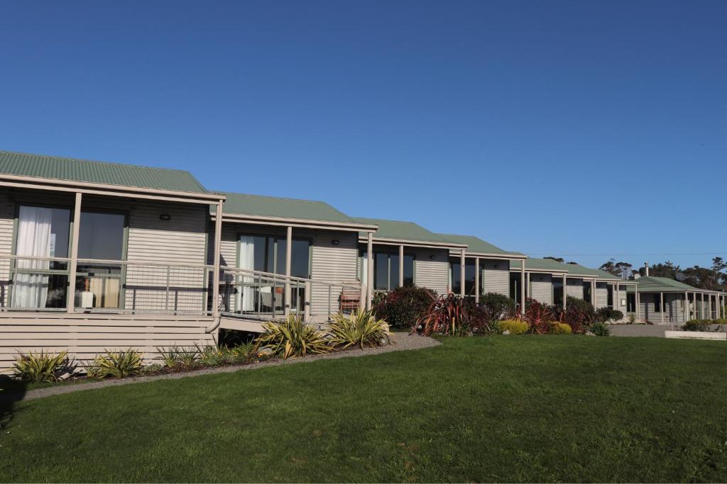 una fila de casas con césped verde en Omau Settlers Lodge Motel en Westport