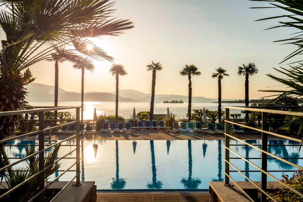 a view of a pool with palm trees and the ocean at Apartment in Manerba del Garda 22048 in Raffa