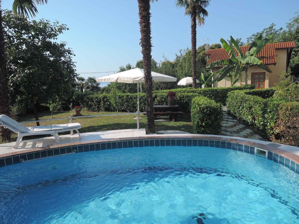 una piscina en un patio con banco y sombrilla en Holiday home in Lovran 15113, en Lovran