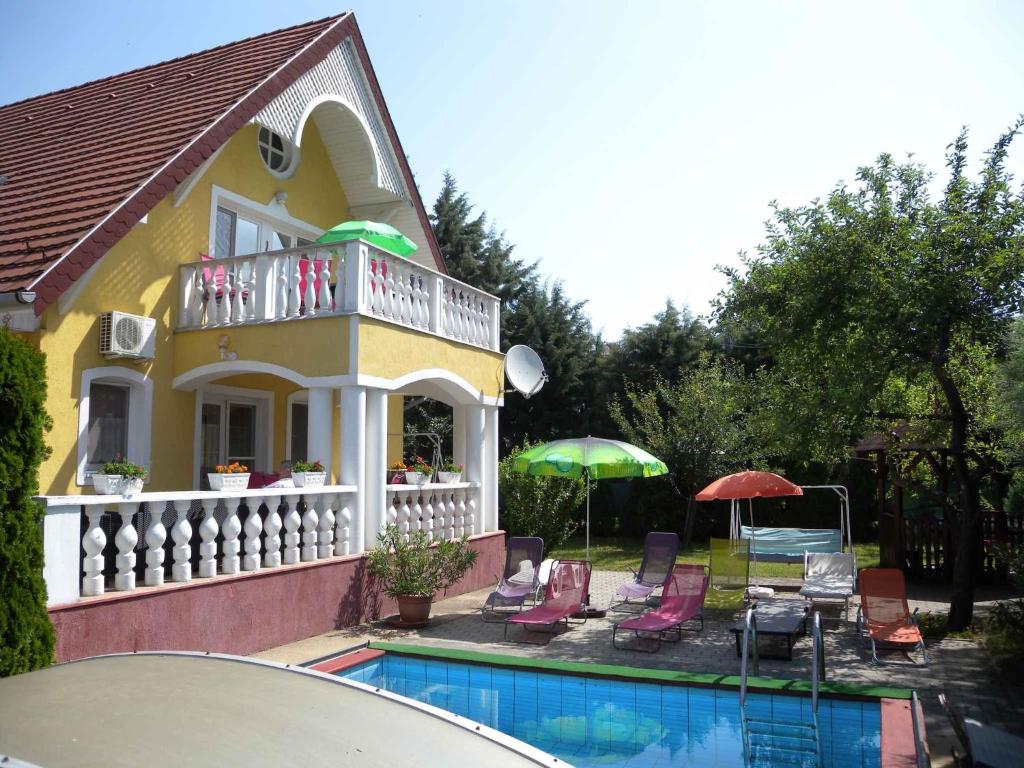 een huis met een zwembad met stoelen en parasols bij Apartment in Badacsony/Balaton 18014 in Badacsonytomaj