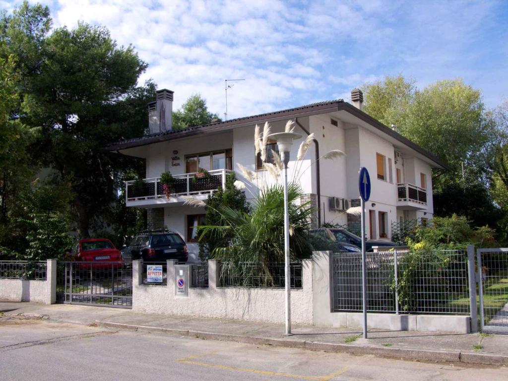 ein weißes Haus mit einem Zaun davor in der Unterkunft Apartments in Lignano 21662 in Lignano Sabbiadoro