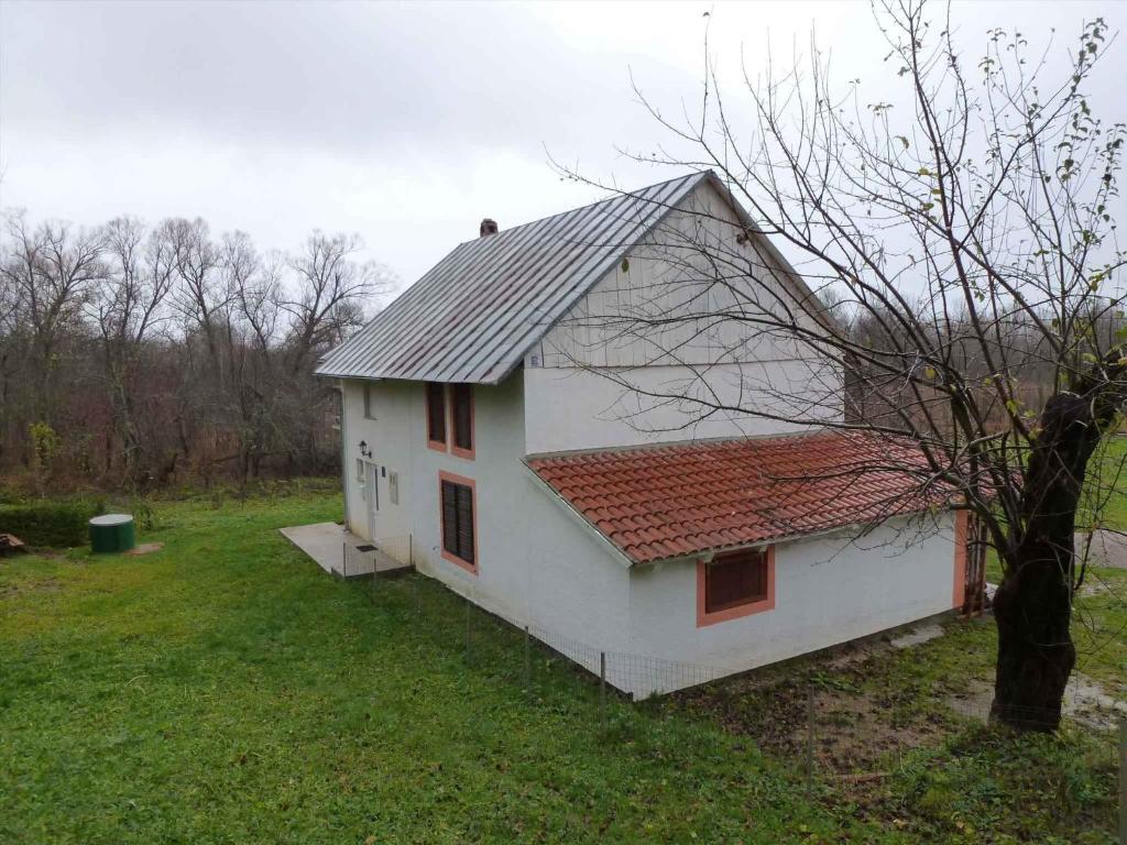 a white house with a red roof in a yard at Holiday home in Trnovac 17132 in Trnovdc
