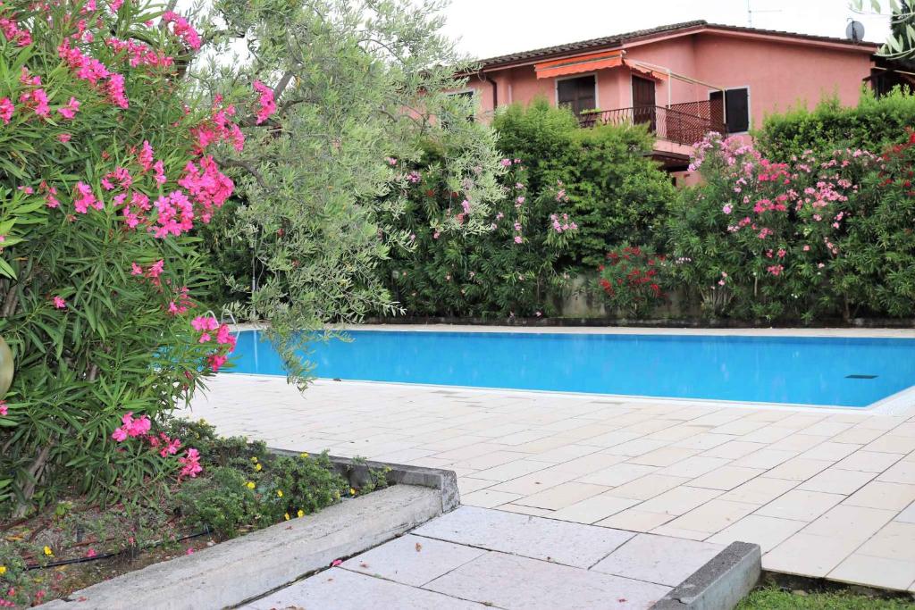 uma piscina num jardim com flores em Apartment in Bardolino/Gardasee 21881 em Bardolino