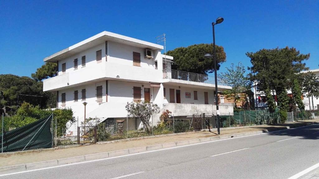 un edificio blanco al costado de una calle en Apartment in Rosolina Mare 33096, en Rosolina Mare