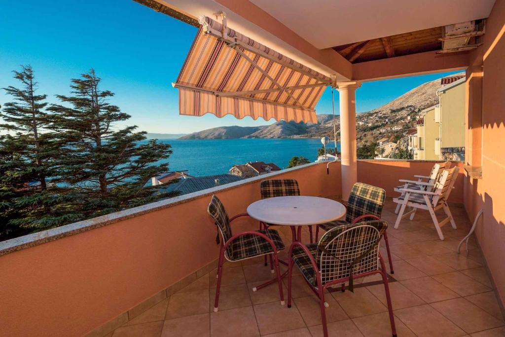 balkon ze stołem i krzesłami oraz oceanem w obiekcie Apartments in Stara Baska - Insel Krk 34433 w mieście Stara Baška