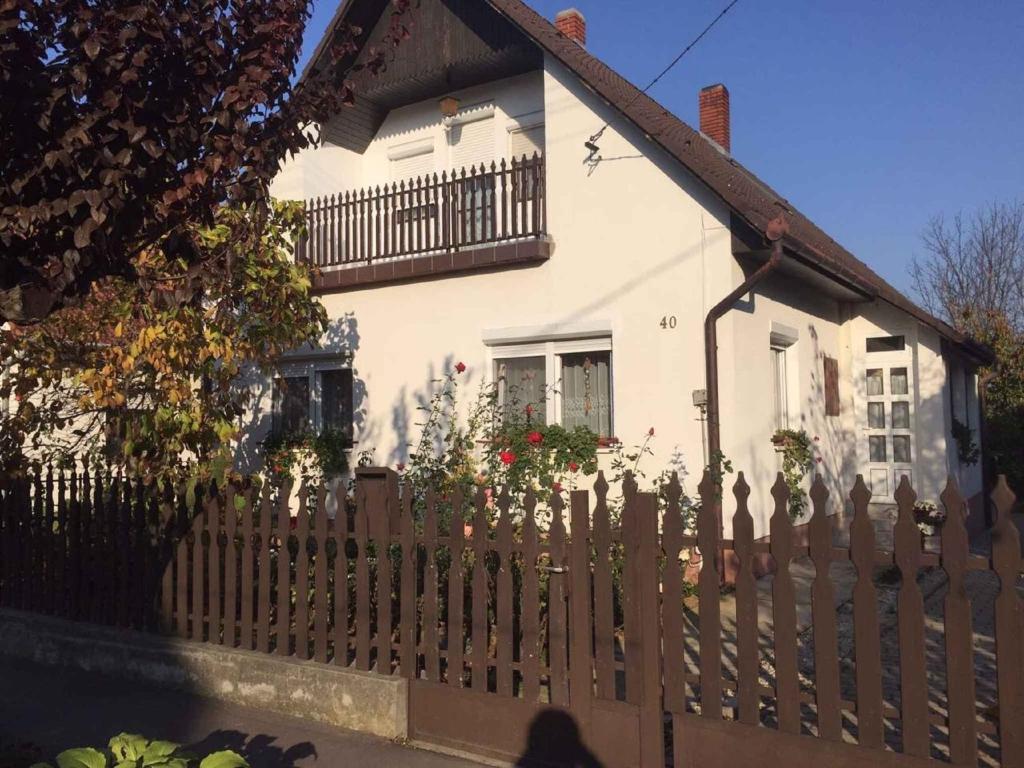 a white house with a wooden picket fence at Apartment in Balatonbereny 35891 in Balatonberény