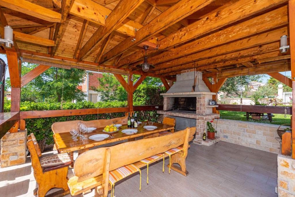 drewniany pawilon ze stołem i kominkiem w obiekcie Studio in Privlaka/Zadar Riviera 7840 w mieście Privlaka