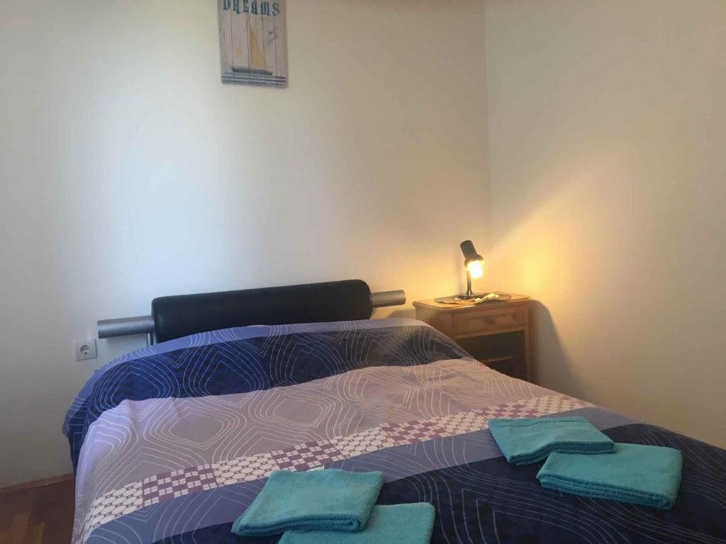 sypialnia z łóżkiem i dwoma ręcznikami na nim w obiekcie Apartments in Klimno - Insel Krk 12514 w mieście Klimno