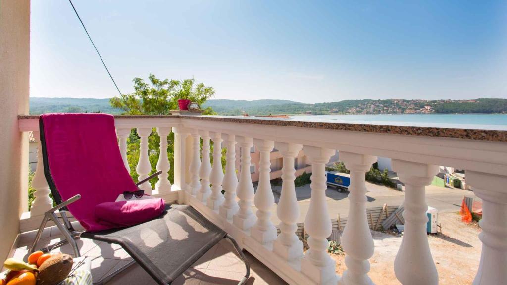 a chair on a balcony with a view of the water at Apartment in Klimno/Insel Krk 12500 in Klimno