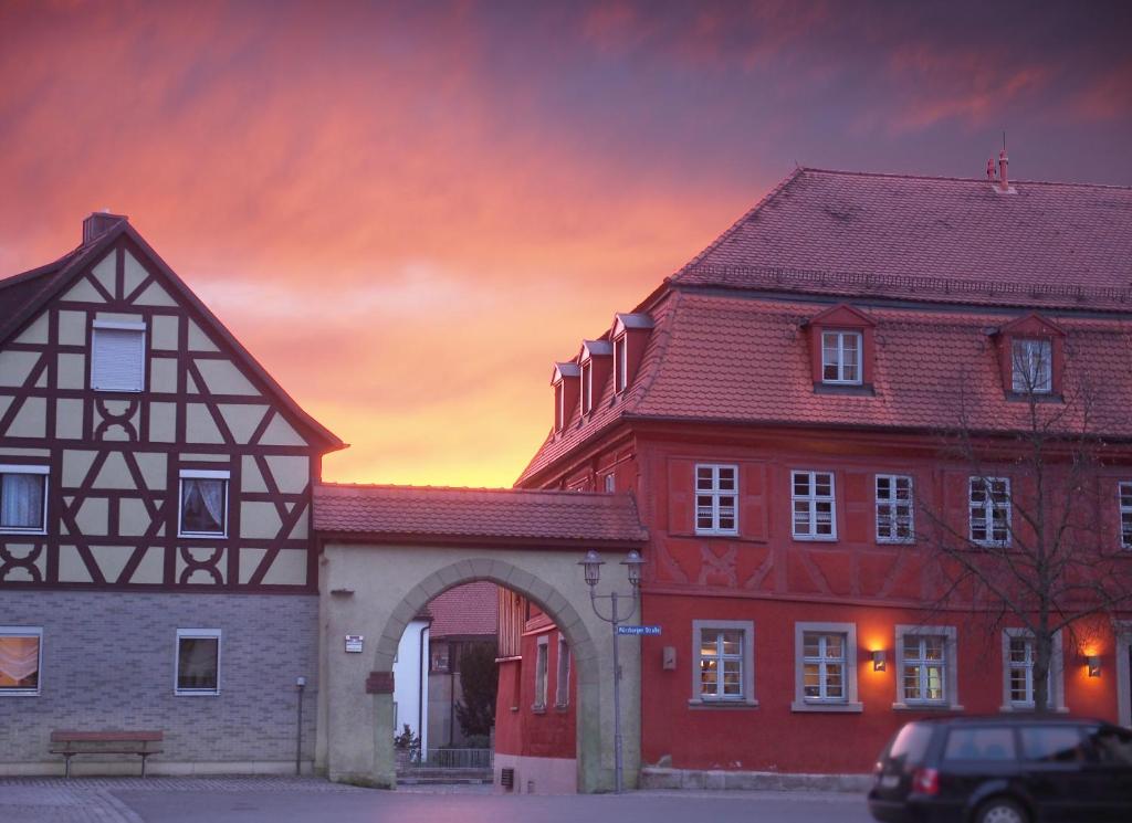 two buildings with a sunset in the background at Rotes Ross Marktbergel in Marktbergel