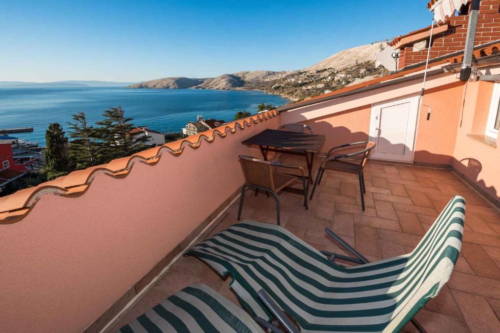 balkon z krzesłami i stołem i oceanem w obiekcie Studio in Stara Baska/Insel Krk 34432 w mieście Stara Baška