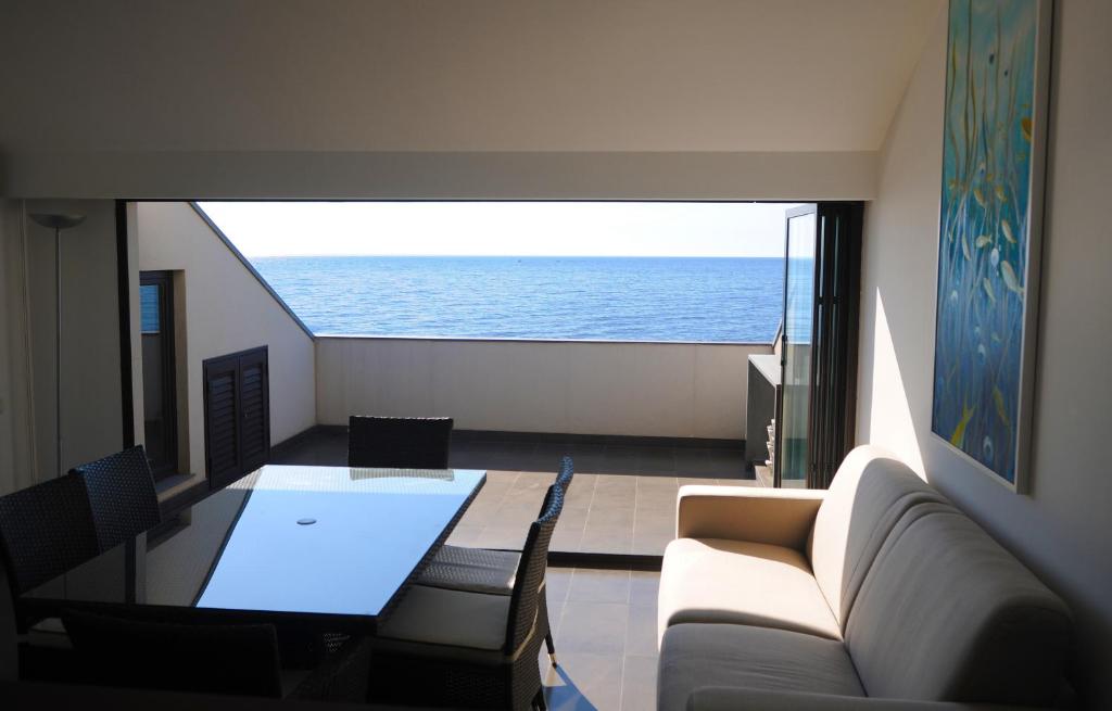un soggiorno con vista sull'oceano di The Roof On The Sea a Fondachello