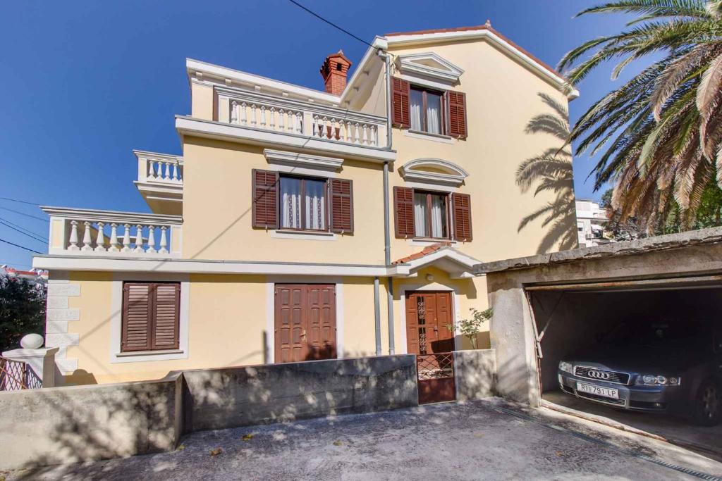 a large house with a garage in front of it at Apartment in Mali Losinj 35205 in Mali Lošinj