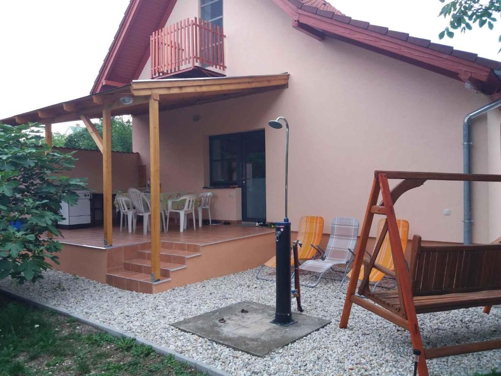 ギェネシュディアーシュにあるHoliday home in Gyenesdias/Balaton 33973のデッキ(テーブル、椅子付)が備わる家
