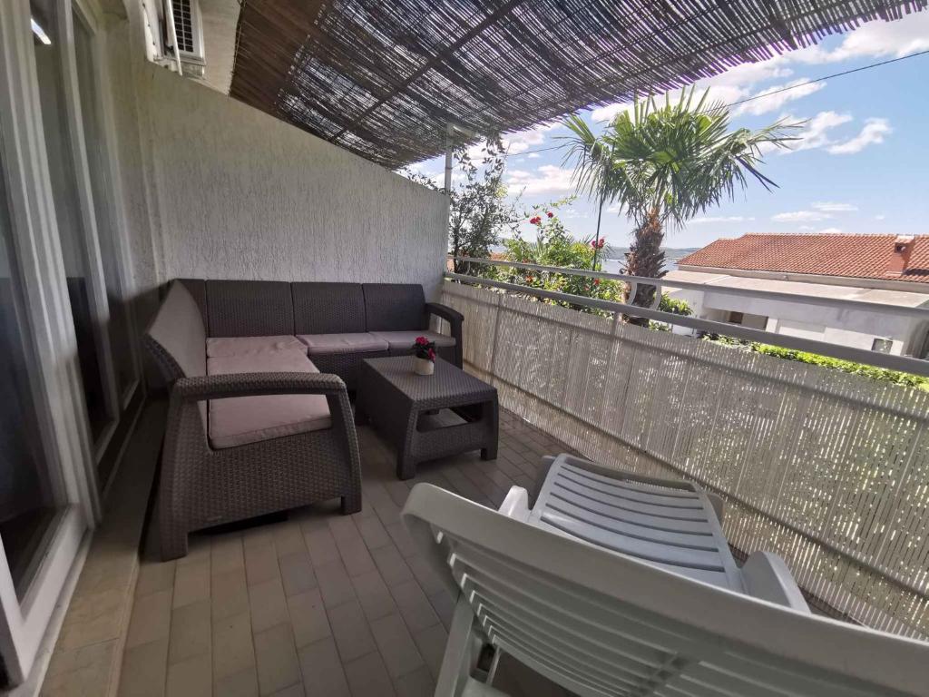 a patio with a couch and a table on a balcony at Apartment in Crikvenica 27813 in Dramalj