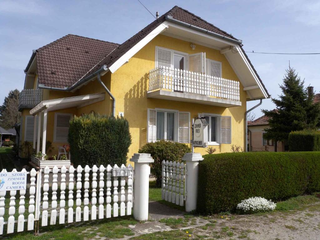 een geel huis met een wit hek bij Apartment in Keszthely/Balaton 18986 in Keszthely