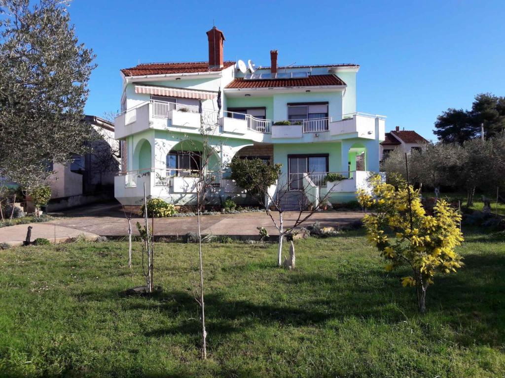 een groot wit huis met bomen in de tuin bij Apartment in Kožin in Kožino