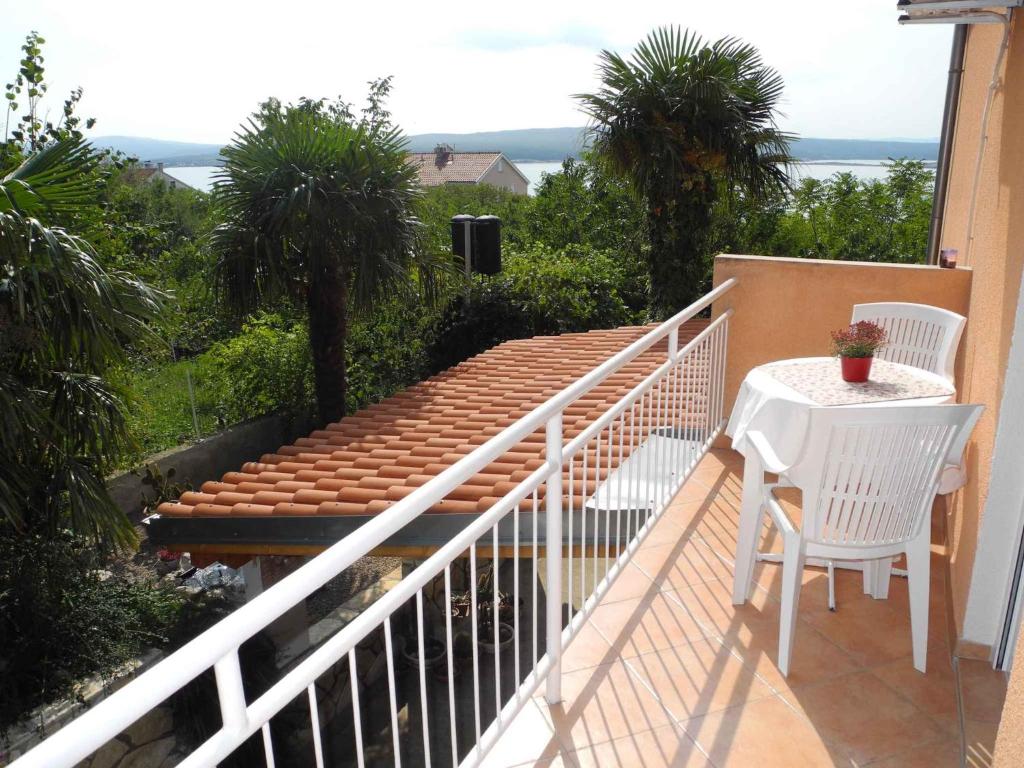 - un balcon avec deux chaises blanches et une table dans l'établissement Apartment in Dramalj 33974, à Dramalj
