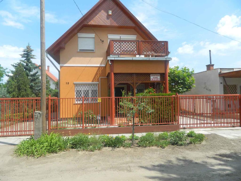 a house with a orange fence in front of it at Apartments in Cserkeszolo/Ostungarn 34460 in Cserkeszőlő