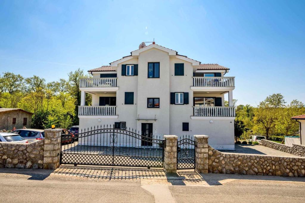 a large white house with a gate in front of it at Apartment in Vantacici/Insel Krk 13135 in Vantačići