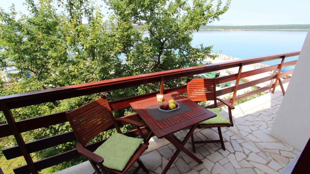 una mesa y sillas en un balcón con vistas al agua en Apartment in Klimno/Insel Krk 33504, en Klimno