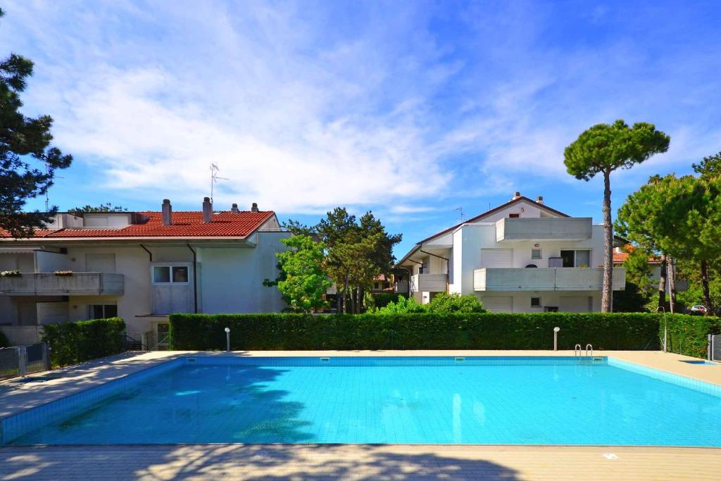 a swimming pool in front of a house at Apartments in Lignano 21597 in Lignano Sabbiadoro