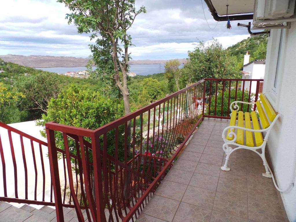 a yellow bench sitting on a balcony with a view at Apartment Karlobag/Velebit Riviera 27804 in Karlobag