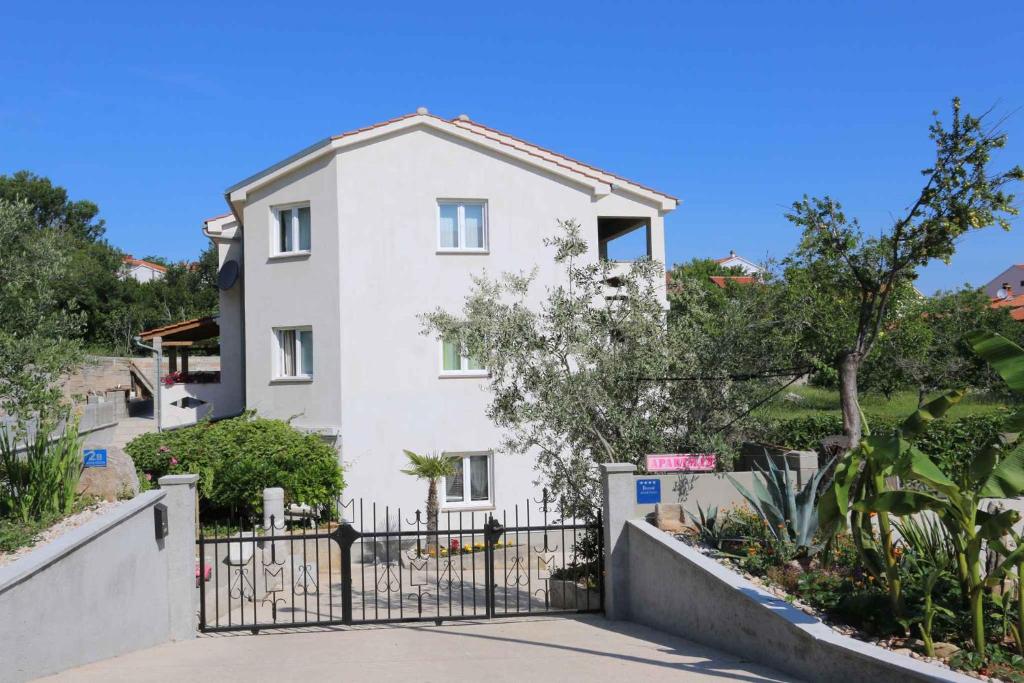 a white house with a gate in front of it at Apartments in Silo/Insel Krk 26753 in Šilo