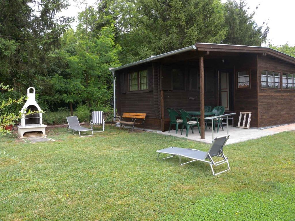 une cabine avec des chaises, une table et une cheminée dans l'établissement Holiday home Balatonfűzfo/Balaton 27729, à Balatonfůzfő