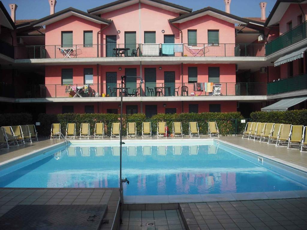a hotel with a swimming pool in front of a building at Apartment in Rosolina Mare 27385 in Rosolina Mare