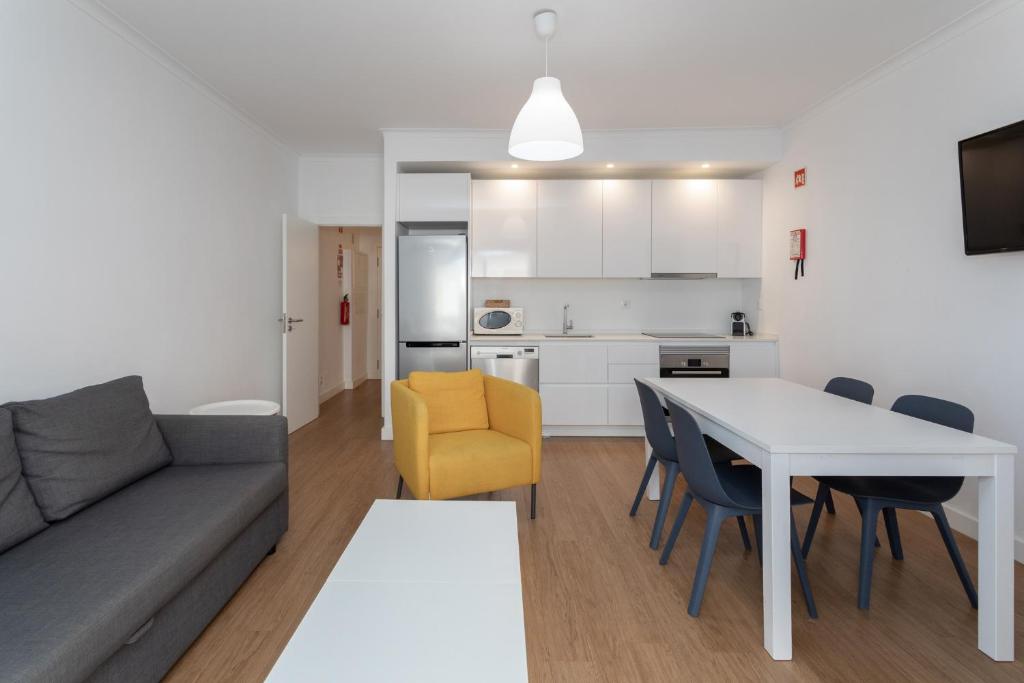 un salon et une cuisine avec un canapé et une table dans l'établissement AL - Apartamentos Vista Mar, à Quarteira