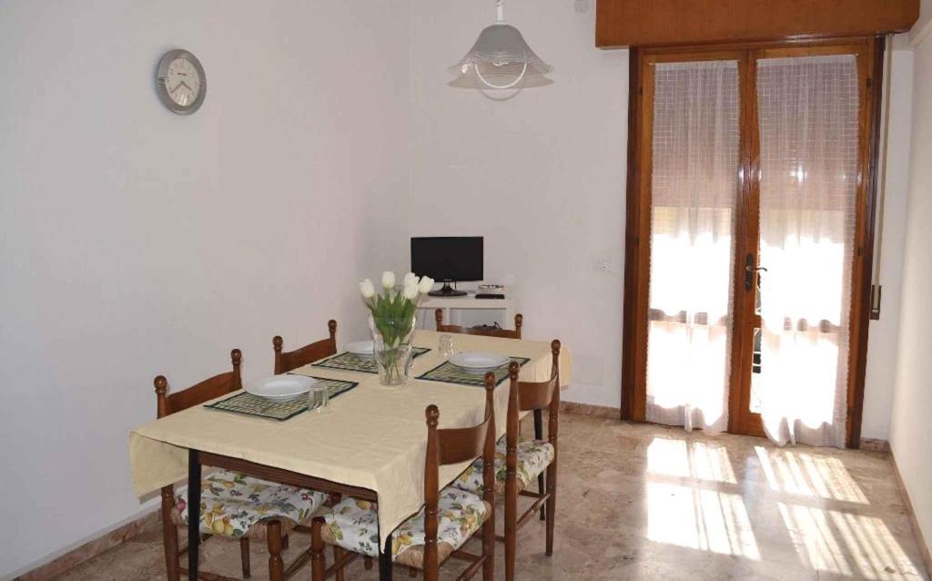 ein Esszimmer mit einem Tisch, Stühlen und einem TV in der Unterkunft Apartment in Eraclea Mare 25149 in Eraclea Mare