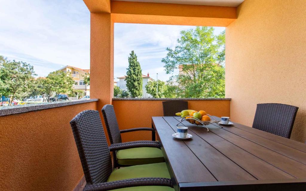 drewniany stół z krzesłami i miska owoców na balkonie w obiekcie Apartment in Silo - Insel Krk 13580 w mieście Šilo