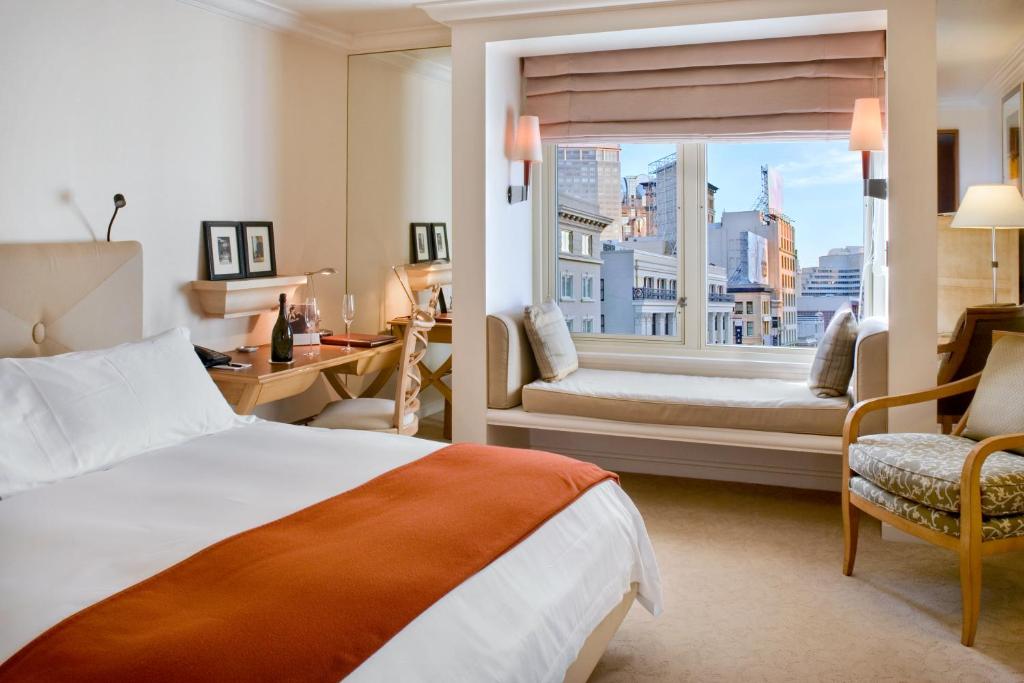 a hotel room with two beds and a large window at Taj Campton Place in San Francisco