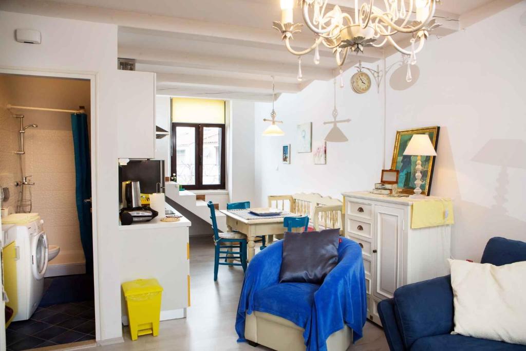 a living room with a blue chair and a table at Apartment in Rovinj/Istrien 11735 in Rovinj