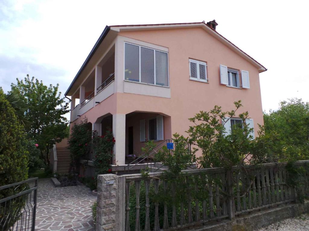 a pink house with a fence in front of it at Apartment in Labin/Istrien 8875 in Raša