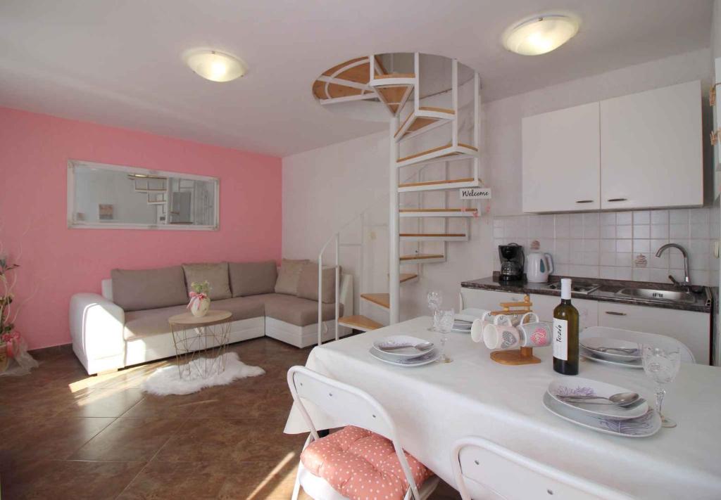 uma sala de estar com uma mesa branca e uma cozinha em Apartment in Porec/Istrien 9920 em Poreč