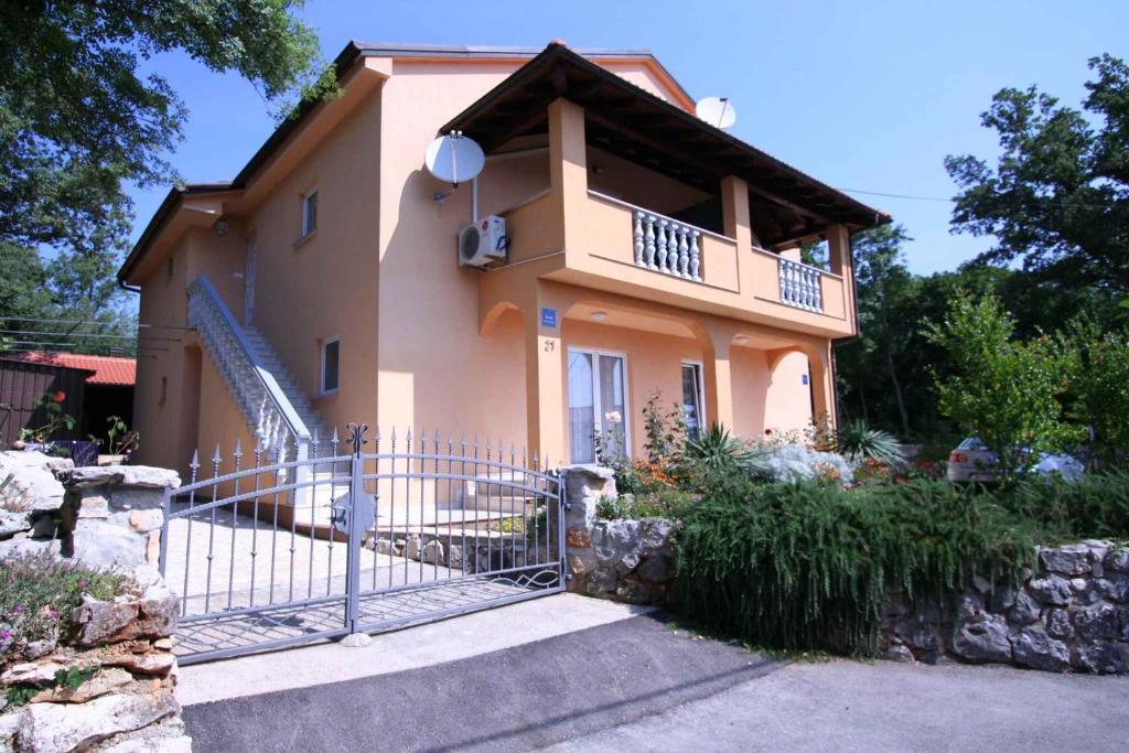 a house with a balcony and a gate at Apartments in Silo/Insel Krk 13442 in Šilo