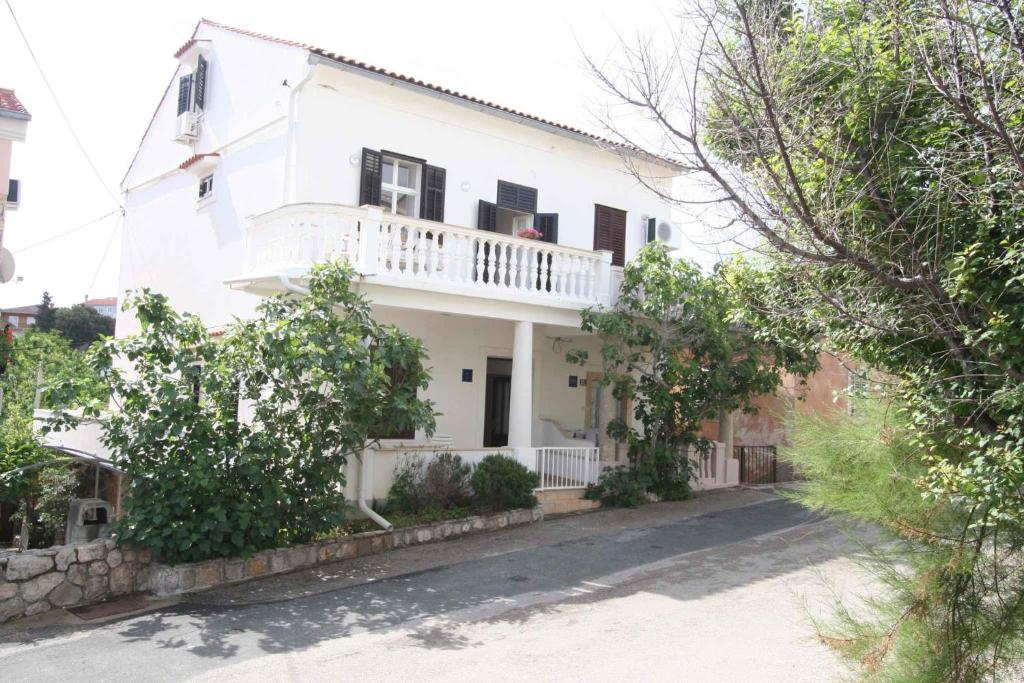 a white house with a balcony on a street at Holiday home in Silo/Insel Krk 26695 in Šilo