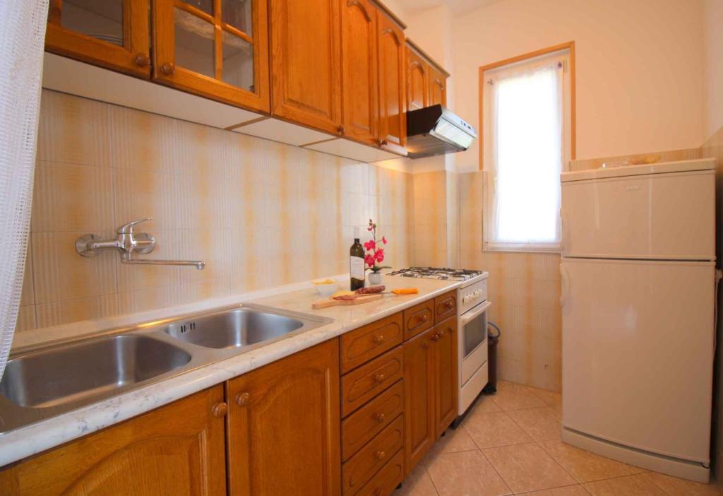 kuchnia ze zlewem i białą lodówką w obiekcie Apartment in Porec/Istrien 10031 w Poreču