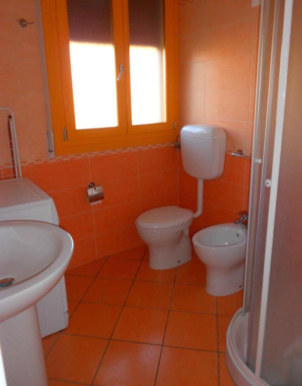 łazienka z 2 toaletami i umywalką w obiekcie Apartments in Rosolina Mare 25092 w mieście Rosolina Mare