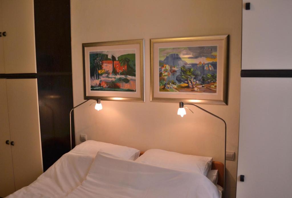 - une chambre avec un lit et 2 photos sur le mur dans l'établissement Apartment Divina Ragusa, à Dubrovnik
