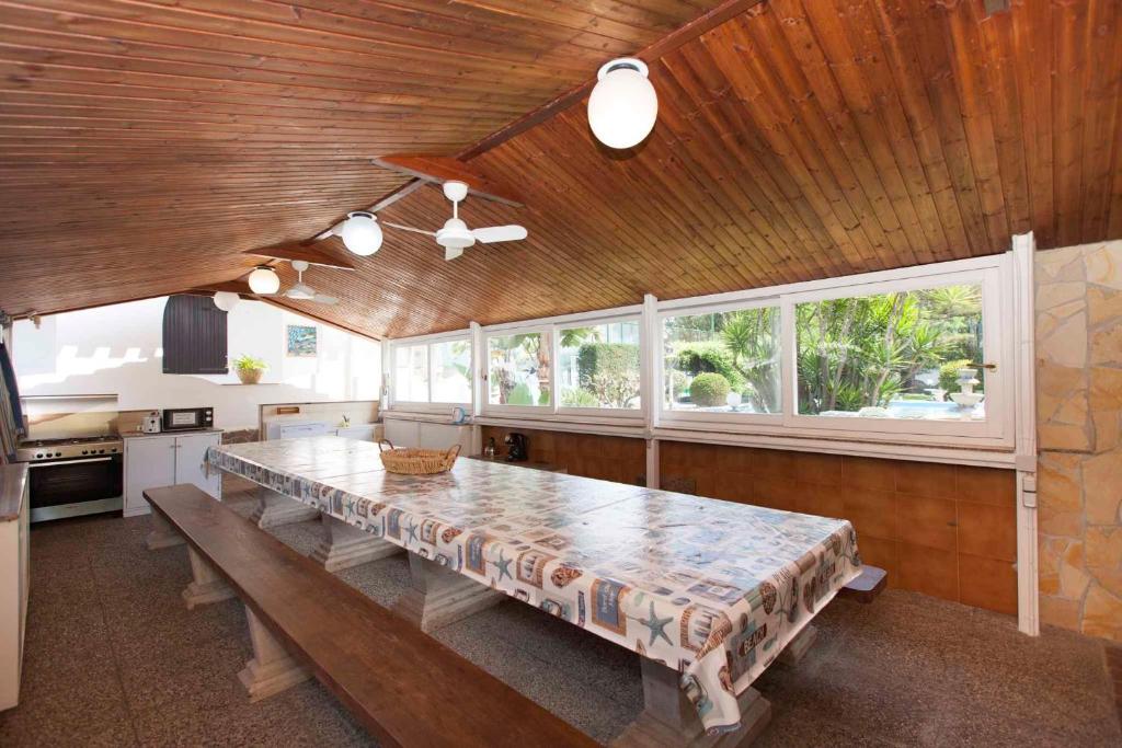 une grande salle à manger avec une grande table et des fenêtres dans l'établissement Holiday home in Quartu Sant'Elena 22916, à Flumini di Quartu