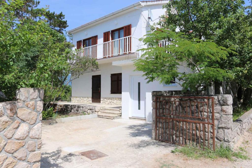 a white house with a gate in front of it at Apartment in Silo/Insel Krk 13562 in Šilo